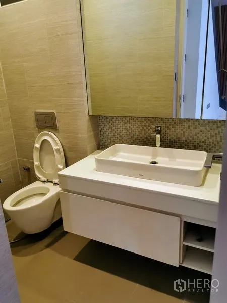 Detached House for sale in Wang Thonglang, Bangkok - Compact guest bathroom with wall-mounted vanity, mirror cabinet and toilet.