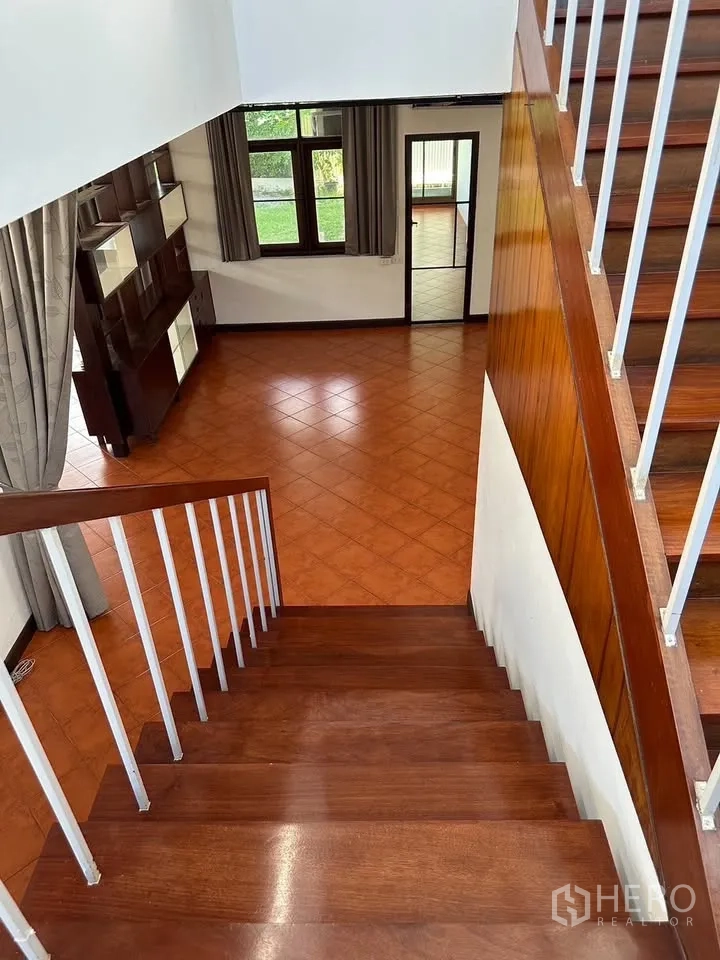 独栋房屋 for rent in Phra Khanong, Bangkok - 从木楼梯俯瞰开放式起居区并可见庭院景观。