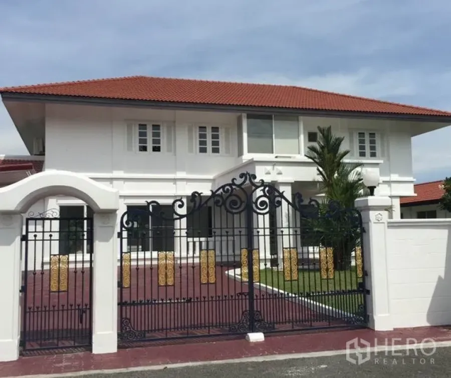 独立式住宅 出租在Bang Phli, Samut Prakan - 两层白色独栋别墅，红色瓦顶，配精美锻铁大门。