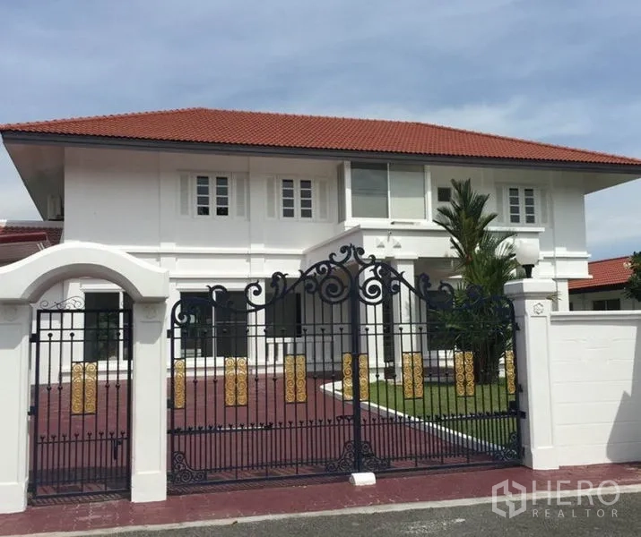 独立式住宅 出租在Bang Phli, Samut Prakan - 两层白色独栋别墅，红色瓦顶，配精美锻铁大门。