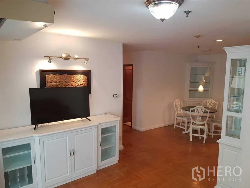 คอนโด ให้เช่าในWatthana, Bangkok - โถงนั่งเล่นเชื่อมพื้นที่รับประทานอาหาร พร้อมตู้บิลท์อินสีขาว ทีวี และโต๊ะกลม