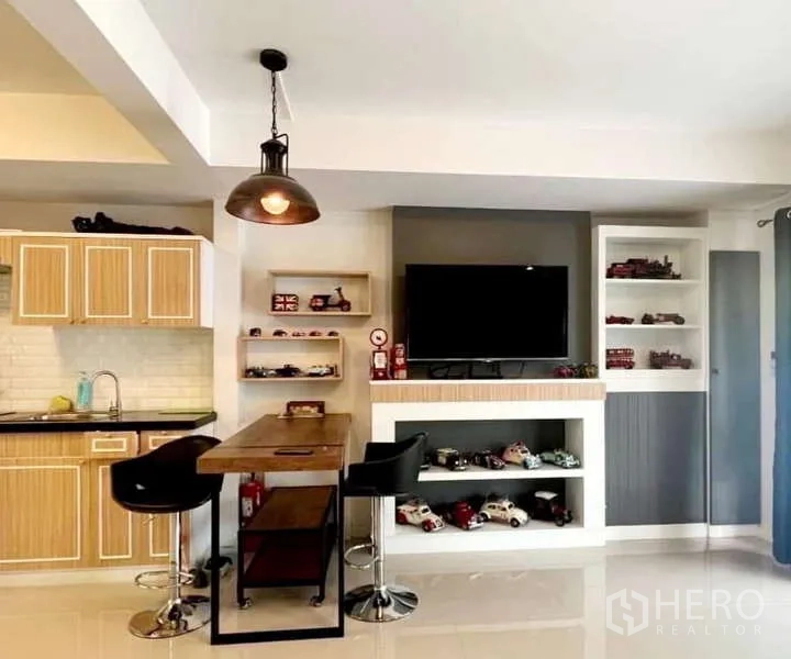 独立式住宅 出租在Bang Phli, Samut Prakan - 餐吧区设高桌与吊灯，旁为电视墙与厨房。