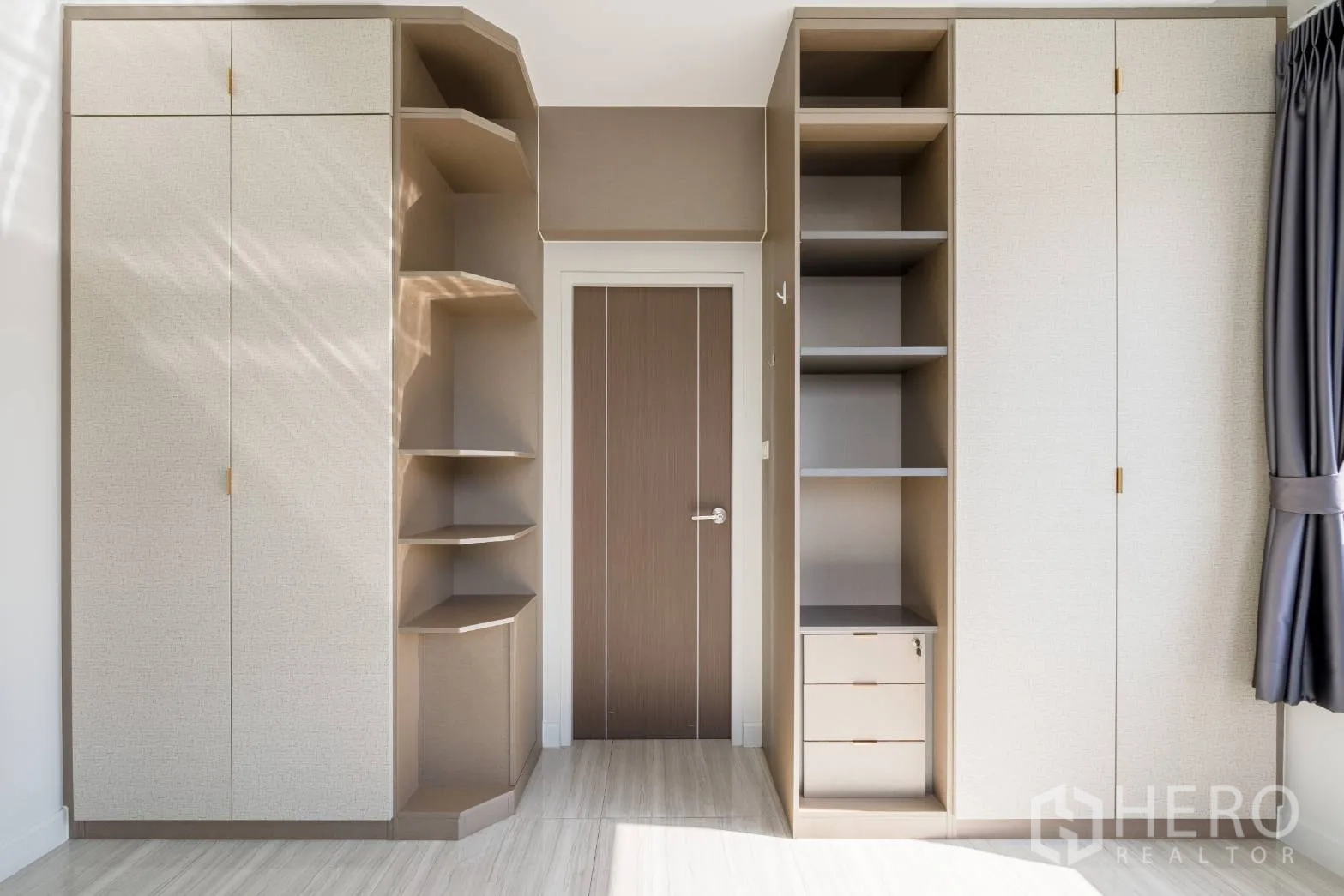 Home Office for rent in Khlong Toei, Bangkok - Built-in wardrobes with open shelving and storage in a sunlit room.