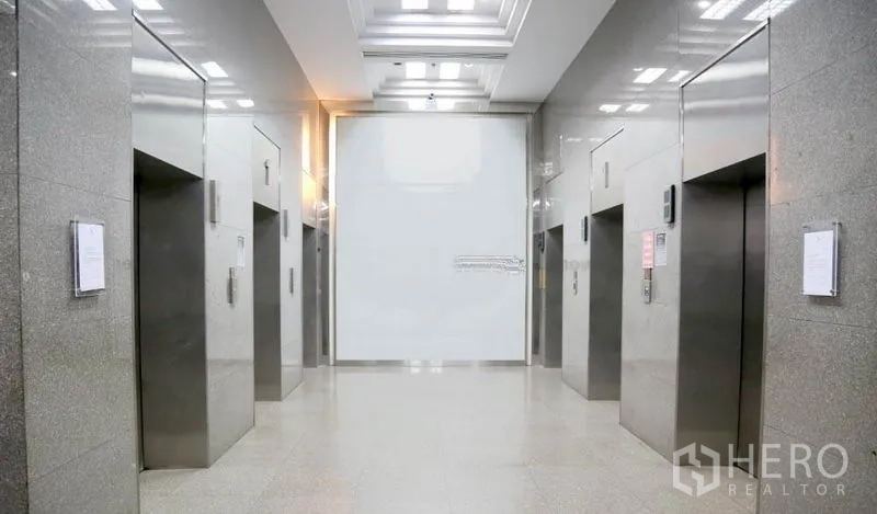 Office Space for rent in Huai Khwang, Bangkok - Modern elevator lobby with multiple stainless-steel lifts.