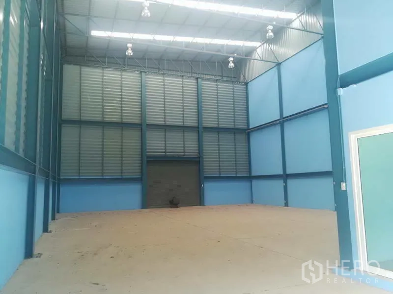 工厂 出售在Sai Noi, Nonthaburi - 挑高仓库大厅，屋顶采光、通风百叶与混凝土地坪。