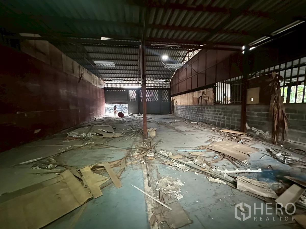 คลังสินค้า ให้เช่าหรือขายในYan Nawa, Bangkok - ทางเดินภายในโกดัง ผนังโลหะ ไฟเพดาน และประตูม้วนด้านท้าย