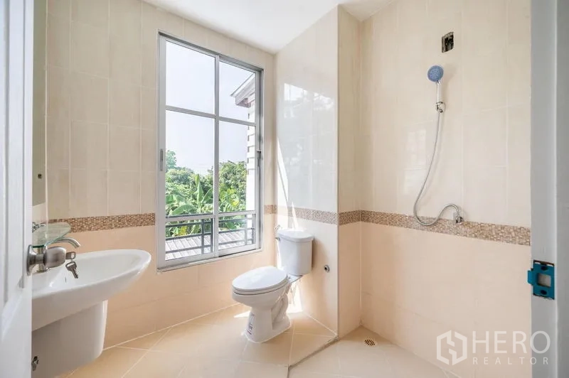 ทาวน์เฮาส์ ขาย - ห้องน้ำสว่าง มีหน้าต่างบานใหญ่ ฝักบัว โถสุขภัณฑ์ และกระเบื้องโทนครีม