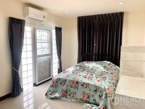Detached House for rent in Khlong Sam Wa, Bangkok - Air‑conditioned bedroom with balcony door, glass blocks, and heavy drapes.