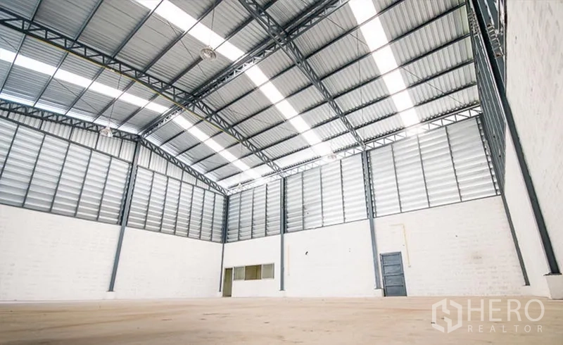 คลังสินค้า ให้เช่าในMueang Samut Prakan, Samut Prakan - ภายในโกดังโปร่ง เพดานโครงเหล็กสูง มีแผ่นรับแสง ช่องลมบานเกล็ด พื้นคอนกรีต และห้องออฟฟิศพร้อมประตูทางบริการด้านข้าง