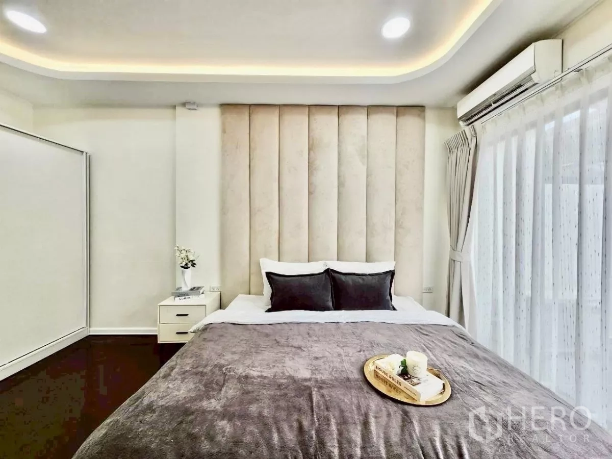 ทาวน์เฮาส์ ให้เช่าในHuai Khwang, Bangkok - ห้องนอนหลัก ผนังหัวเตียงบุซอฟต์ไลท์ หน้าต่างบานใหญ่ผ้าม่านโปร่ง