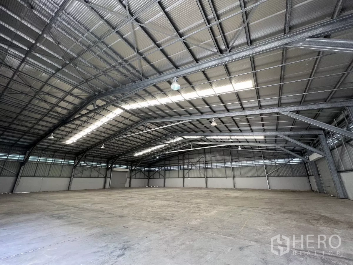 货栈 出租在Sai Mai, Bangkok - 宽敞仓库地面，约9米屋脊高度与钢结构框架，适合货柜车通行。