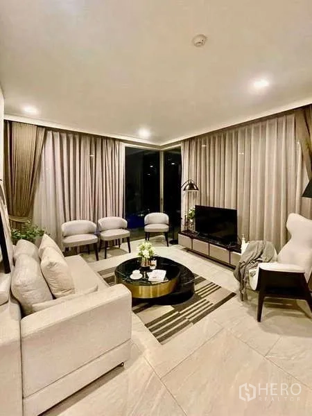 คอนโด ให้เช่าในWatthana, Bangkok - มุมห้องนั่งเล่นสว่างด้วยม่านสูง จโต๊ะกาแฟหินอ่อนทรงกลม และทีวี