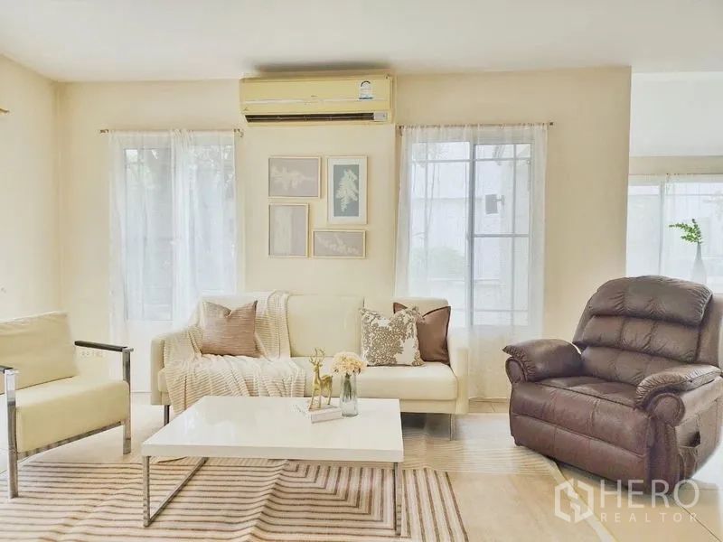 独立式住宅 出租在Prawet, Bangkok - 温馨客厅，沙发组合、躺椅与茶几，充足自然光。