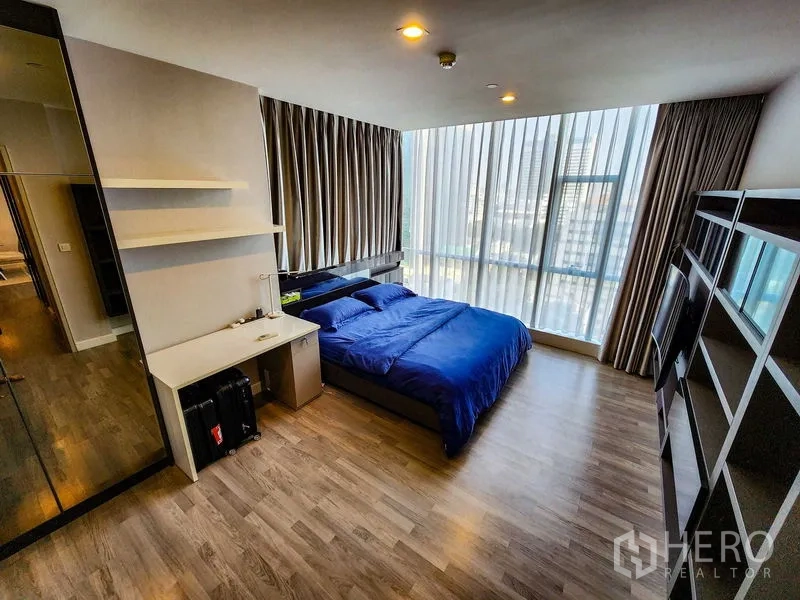 คอนโด ให้เช่าหรือขายในBang Rak, Bangkok - ห้องนอนใหญ่กว้าง ผ้าปูสีน้ำเงิน และกระจกเต็มผนังรับแสง