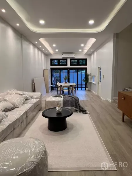 Townhouse for rent - Open-plan lounge and dining area with high ceilings, wood floors and glass doors leading to the patio.