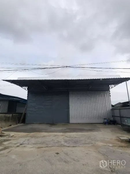 Warehouse for rent in Min Buri, Bangkok - Warehouse exterior in Min Buri with wide sliding metal doors and a covered loading apron.