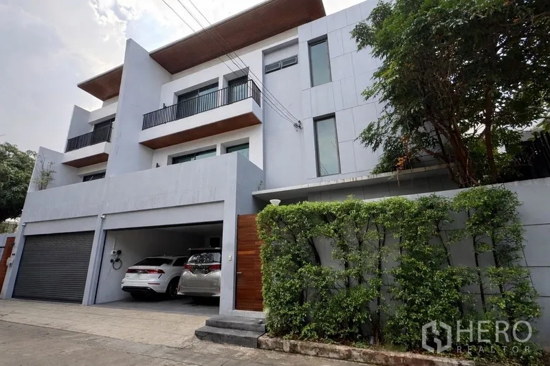 Semi-detached House for rent in Watthana, Bangkok - Modern three-storey semi-detached house facade with garage parking.