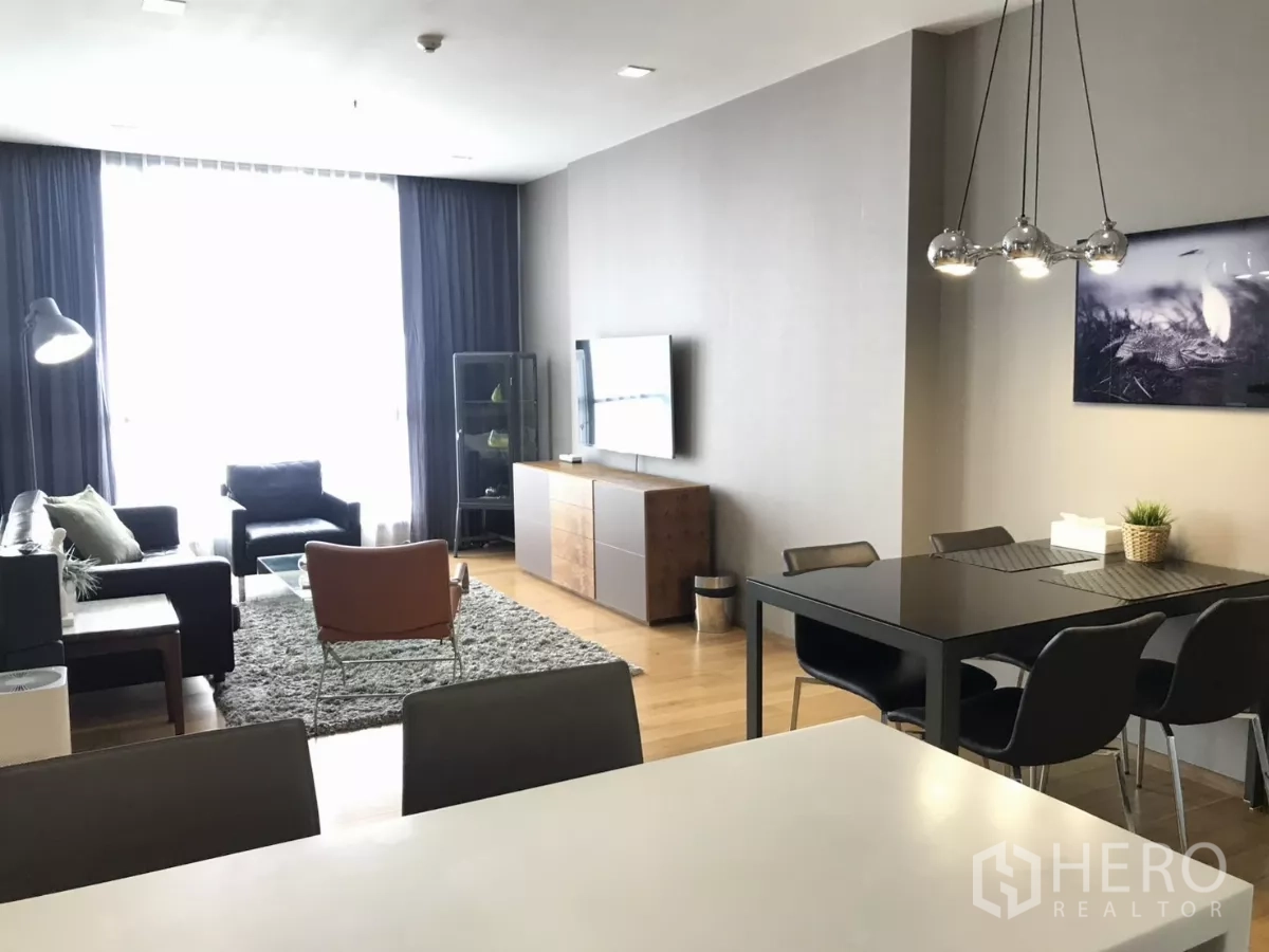 Condominium for rent in Watthana, Bangkok - Spacious, light-filled living and dining area with large window and pendant lights.
