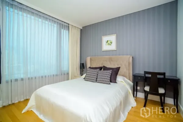 คอนโด ให้เช่าในKhlong Toei, Bangkok - ห้องนอนที่สาม มีหัวเตียงหุ้มผ้า โต๊ะทำงาน วิวเมืองจากหน้าต่างบานใหญ่ และผนังไฮไลต์สีน้ำเงิน