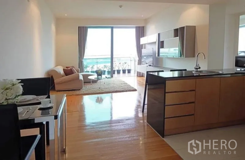 Condominium for rent or sale in Yan Nawa, Bangkok - Open-plan living, dining and kitchen leading to a river-view balcony.