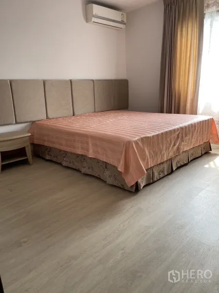 公寓 出租或出售在Watthana, Bangkok - 明亮主卧，软包床头、空调与浅色木地板。
