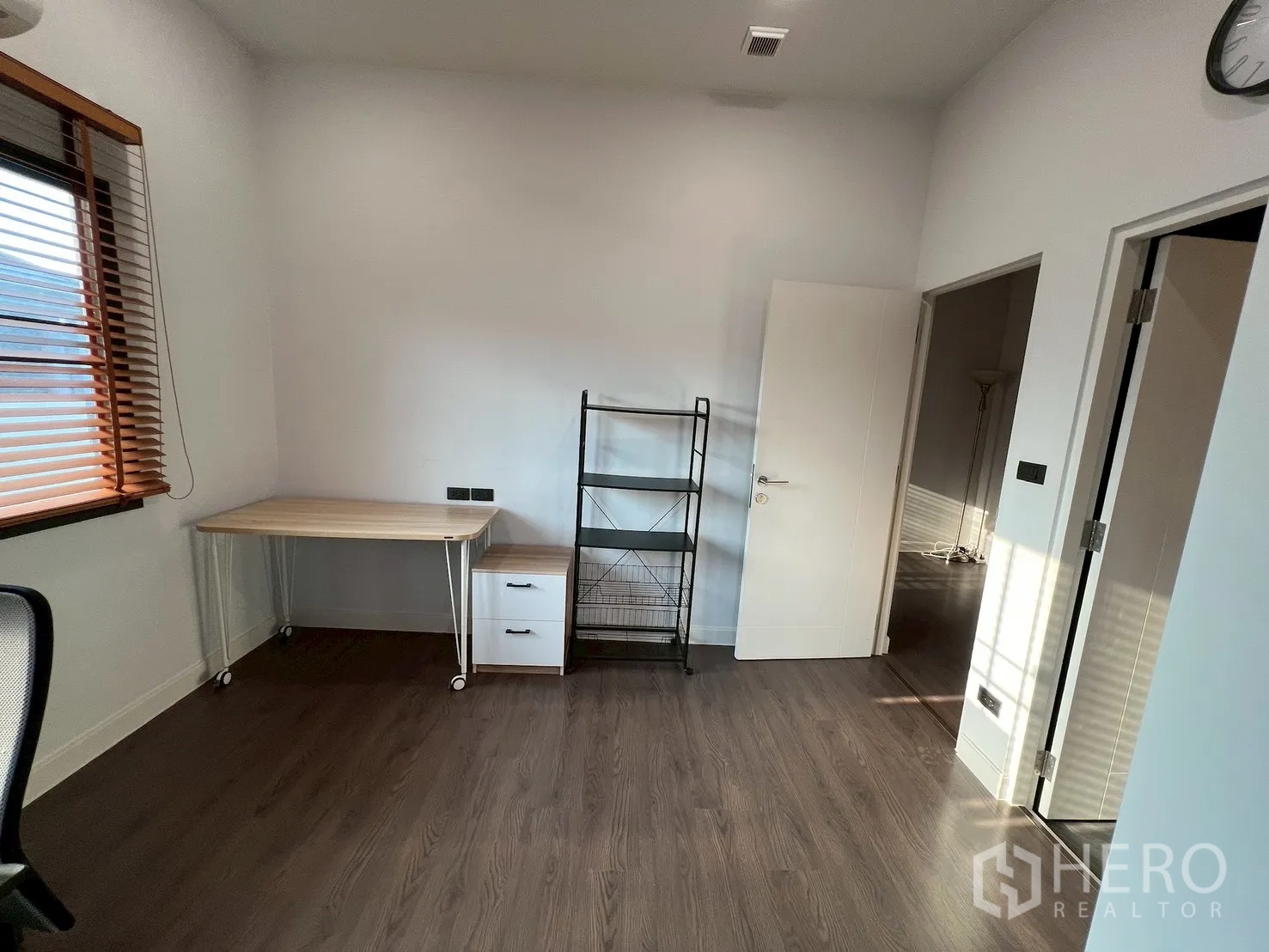 独栋房屋 for rent in Bang Kapi, Bangkok - 书房一角，带滚轮桌与金属置物架，木地板。