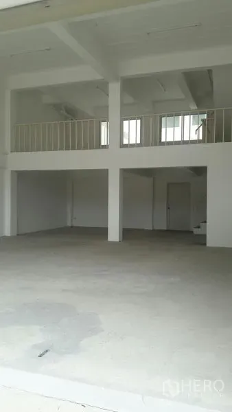 Office Space for sale in Khlong Luang, Pathum Thani - Spacious interior with concrete floor, columns, mezzanine platform, stairway and ceiling lighting.