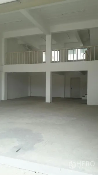 Office Space for sale in Khlong Luang, Pathum Thani - Spacious interior with concrete floor, columns, mezzanine platform, stairway and ceiling lighting.