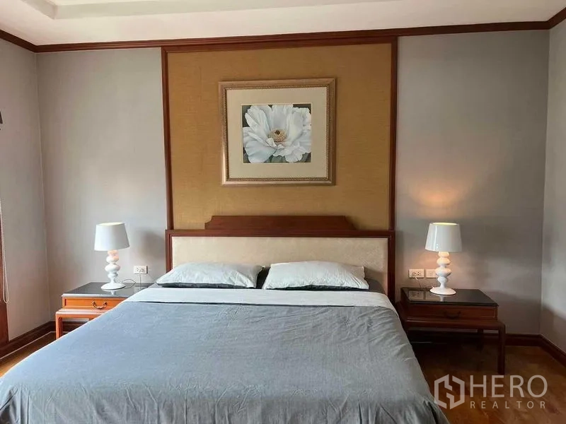 公寓 出租或出售在Watthana, Bangkok - 静谧卧室，特大床、床头柜台灯与花卉装饰画