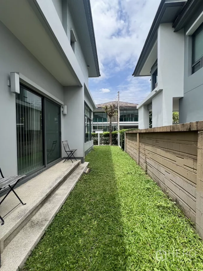 Detached House for rent in Bang Kapi, Bangkok - Narrow side garden between houses with grass strip and steps.