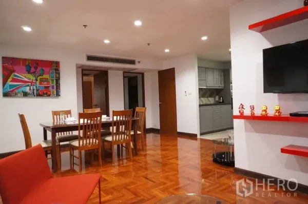 Condominium for rent in Watthana, Bangkok - Open-plan dining for six beside colorful artwork, recessed lighting and access to the gray kitchen.