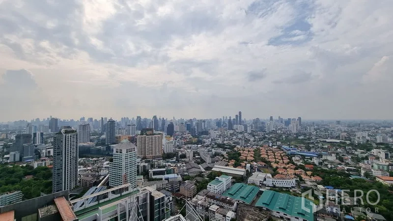 公寓 出售在Watthana, Bangkok - 高楼层全景，俯瞰曼谷天际线与城市景观，云层漫布。