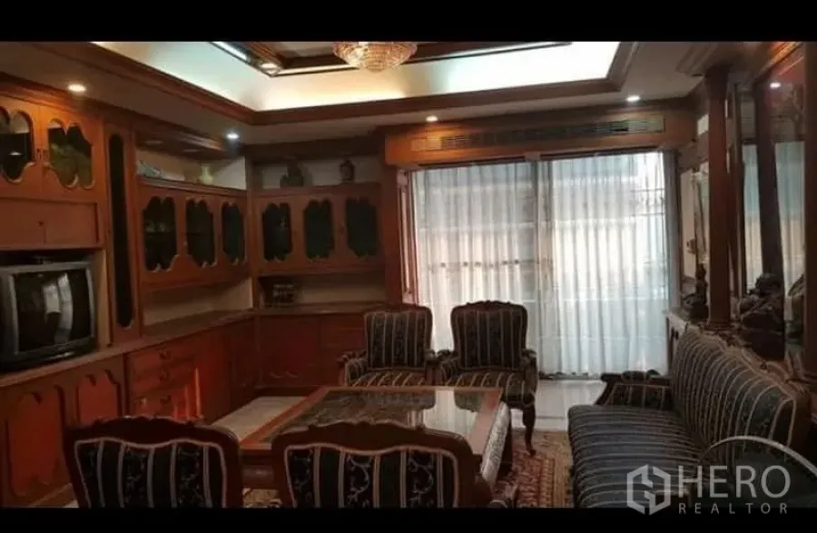 คอนโด ให้เช่าหรือขายในWatthana, Bangkok - ห้องนั่งเล่นตกแต่งบิลท์อินไม้ เพดานดาวน์ไลท์พร้อมโคมระย้า โซฟาลายและผ้าม่านโปร่งติดหน้าต่างระเบียง