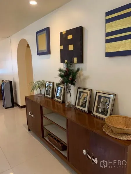 ทาวน์เฮาส์ ให้เช่าหรือขายในPhra Khanong, Bangkok - โถงทางเดินพร้อมตู้ไม้สไตล์วินเทจ ไฟดาวน์ไลท์ และภาพตกแต่ง