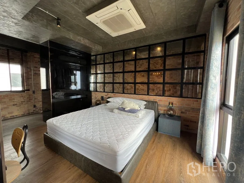 联排别墅 出租在Saphan Sung, Bangkok - 工业风卧室，砖墙与网格背景墙，配大床。