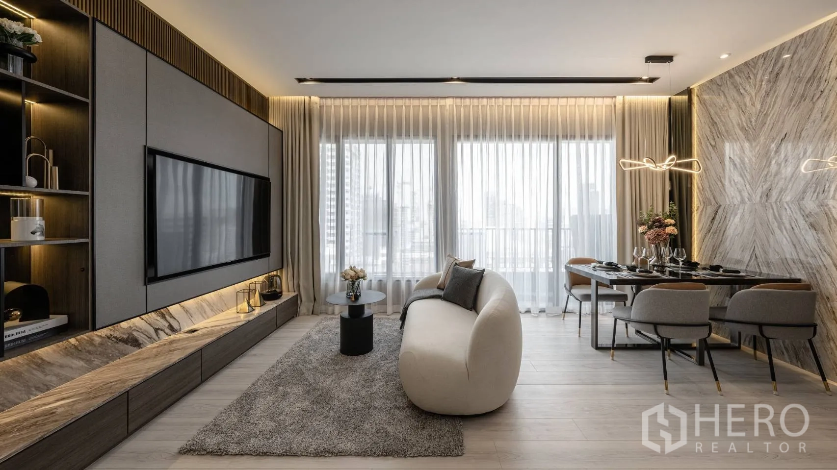 公寓 出售在Ratchathewi, Bangkok - 明亮的客餐空间，石纹装饰墙与纱帘，眺望城市景观。