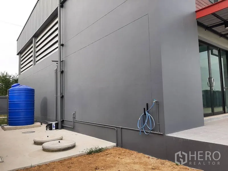 โรงงาน ให้เช่าหรือขายในLam Luk Ka, Pathum Thani - โซนยูทิลิตี้ภายนอกพร้อมถังเก็บน้ำสีน้ำเงิน ระบบท่อ และทางบริการ