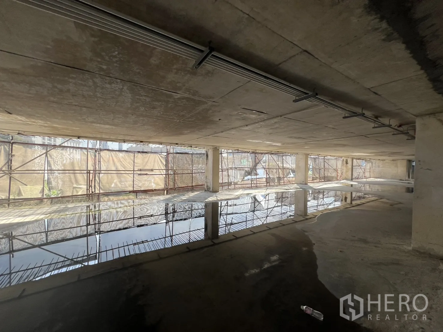 独立商业地产 出售在Watthana, Bangkok - 半封闭楼层，水面反光与临时防护网。