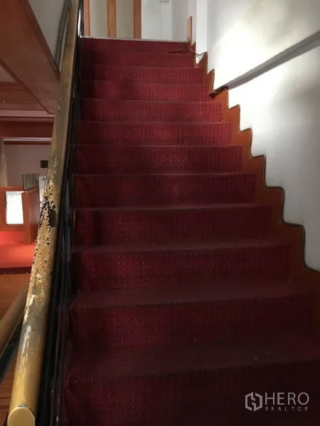 零售空间 出租在Watthana, Bangkok - 室内楼梯铺红地毯，木扶手连接各楼层。