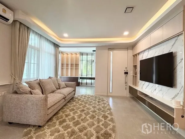 บ้าน ให้เช่าหรือขายในPrawet, Bangkok - ห้องนั่งเล่นสว่างโปร่ง บ้านเดี่ยวประเวศ กรุงเทพฯ พร้อมหน้าต่างบานใหญ่ โซฟา และผนังทีวีลายหินอ่อน