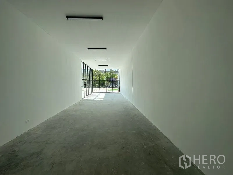 คลังสินค้า ให้เช่าในBang Phli, Samut Prakan - ห้องโชว์รูมยาวโทนสีขาว มองออกสู่ด้านหน้าผ่านกระจกสูงเต็มผนัง