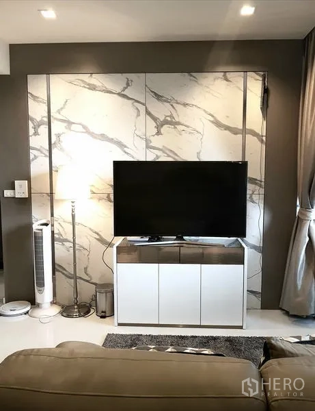 Condominium for rent in Sathon, Bangkok - TV wall with marble panels, media console and ambient lighting.