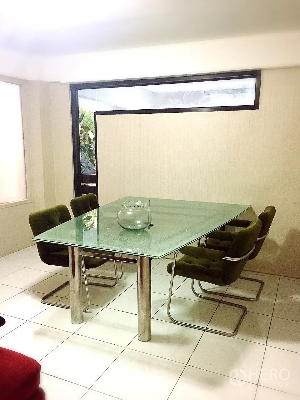 Detached House for rent in Wang Thonglang, Bangkok - Bright dining room with glass-top table and green velvet chairs beside a large window.