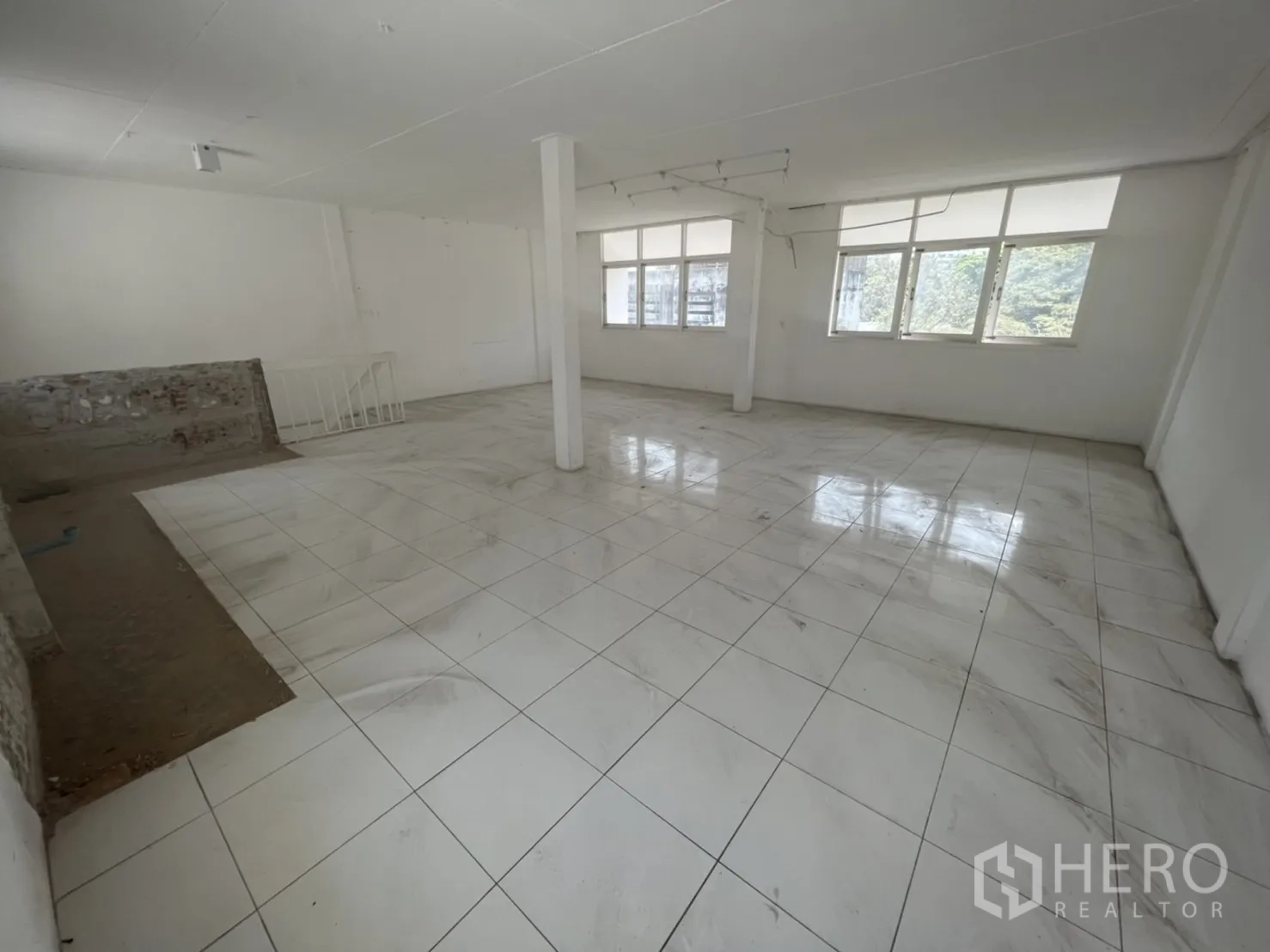 店屋 出租在Watthana, Bangkok - 大面积开放房间，亮白地砖，靠窗有立柱。