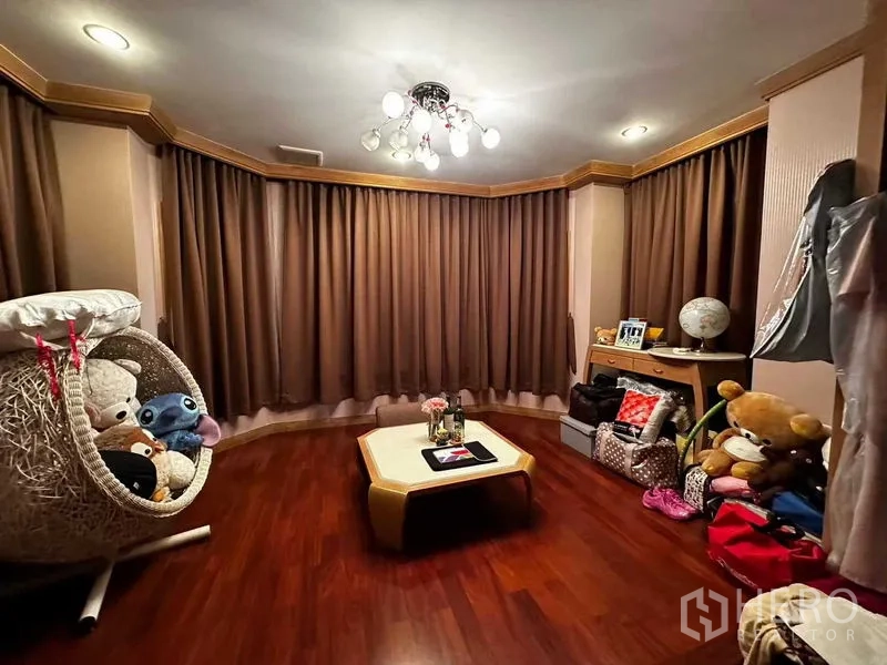 Detached House for sale in Bang Khun Thian, Bangkok - Cozy family room with wood flooring, bay windows and a modern ceiling light.