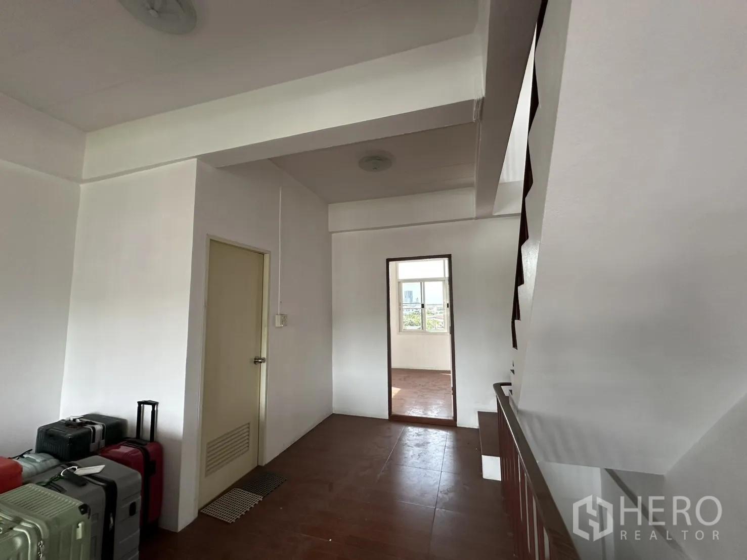 店屋 for rent in Phra Khanong, Bangkok - 楼层过道放置行李箱并通往另一房间。