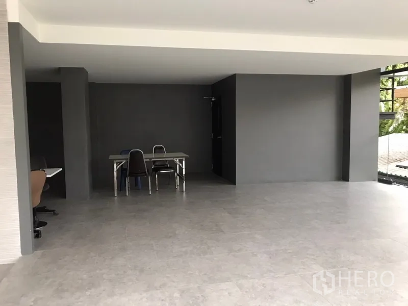 零售空间 出租在Khlong Toei, Bangkok - 转角零售空间，开放布局、灰色墙面与自然采光。