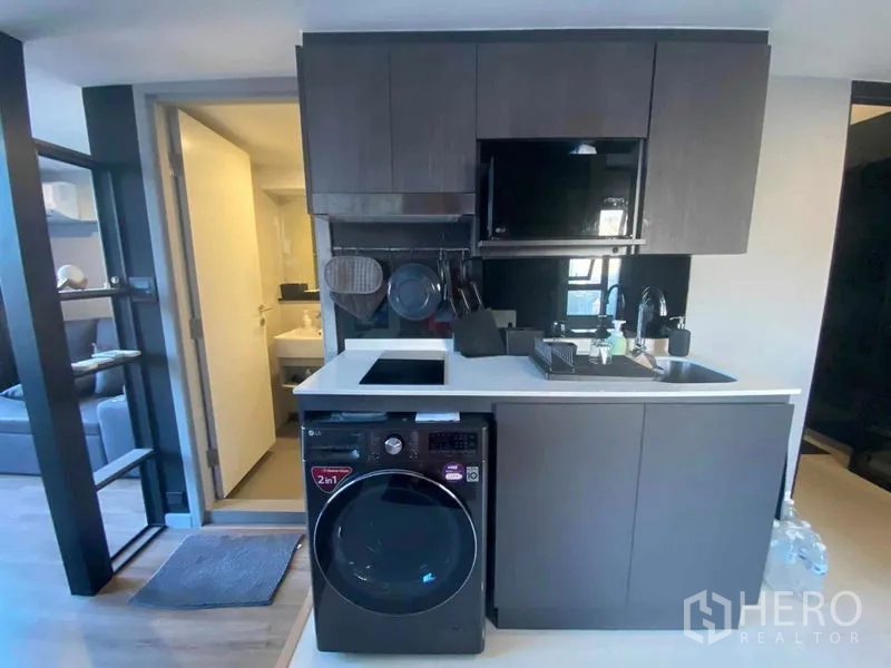 公寓 出租或出售在Sathon, Bangkok - 紧凑厨房配嵌入式家电与洗烘一体机。