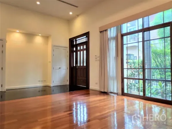 独立式住宅 出租在Watthana, Bangkok - 采光充足的客厅，挑高天花，落地推拉门通向花园，靠近入户门。