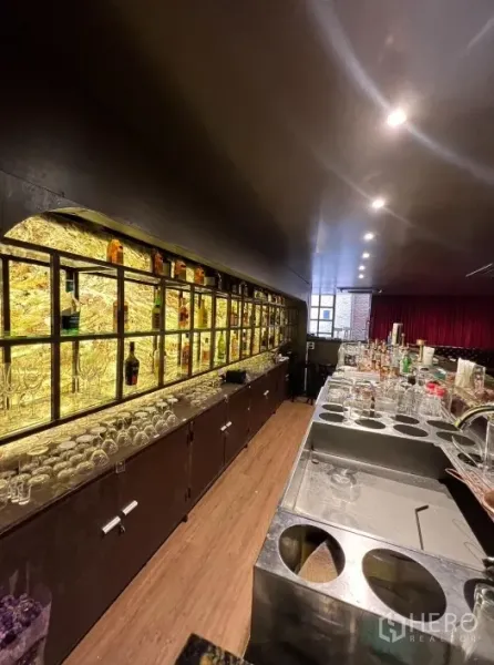 零售空间 出租在Watthana, Bangkok - 吧台工作区特写，带发光酒瓶墙与水槽